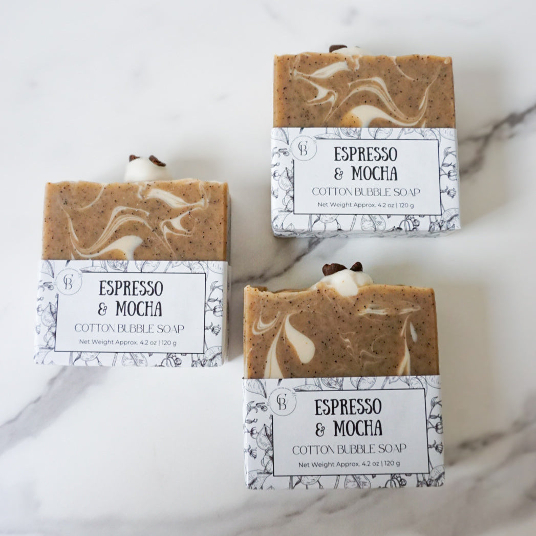 Three bars of Espresso & Mocha soap with packaging on a marble surface