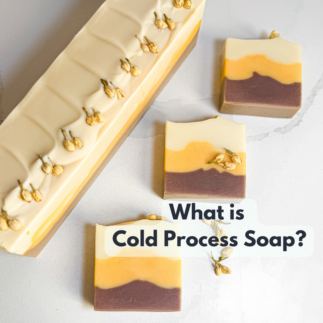 "what is cold process soap?" written on a background with 3 soaps and 1 soap log