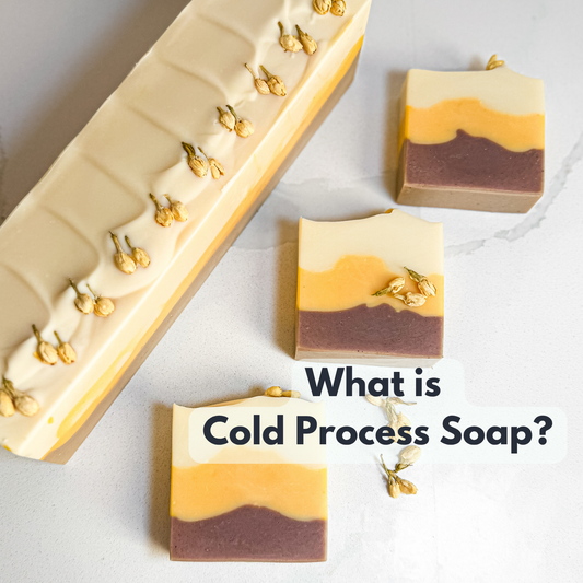 "what is cold process soap?" written on a background with 3 soaps and 1 soap log