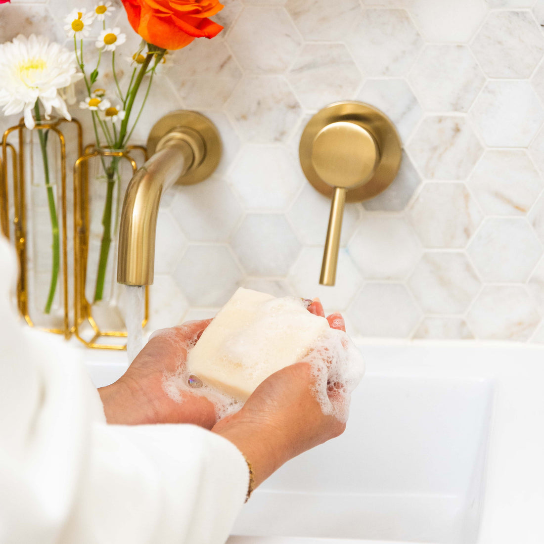 two hands holding a lathered white soap