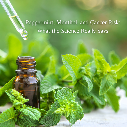 essential oil vial with a dropper surrounded by fresh mint plants