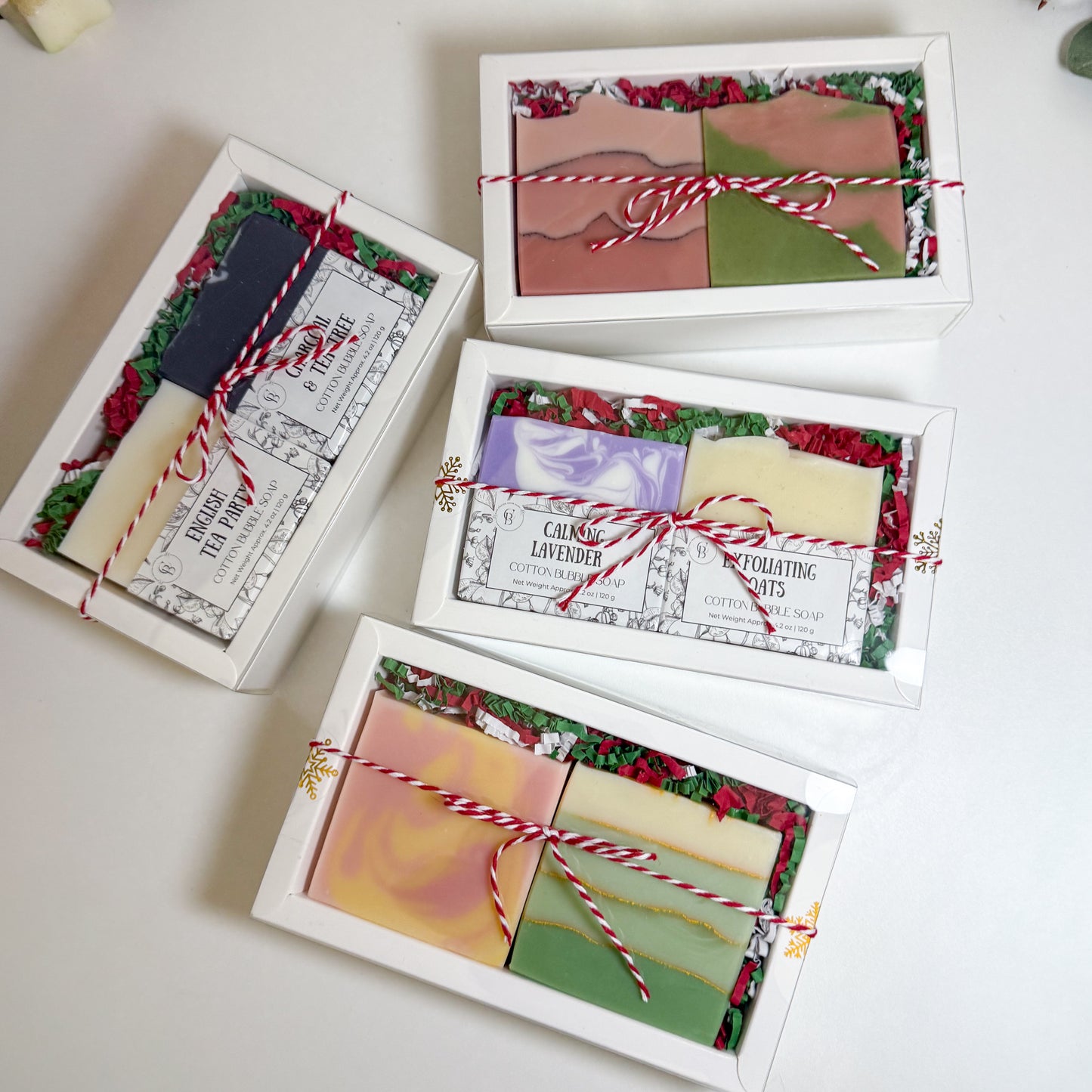 Set of soap bars in decorative boxes with colorful labels on a white surface