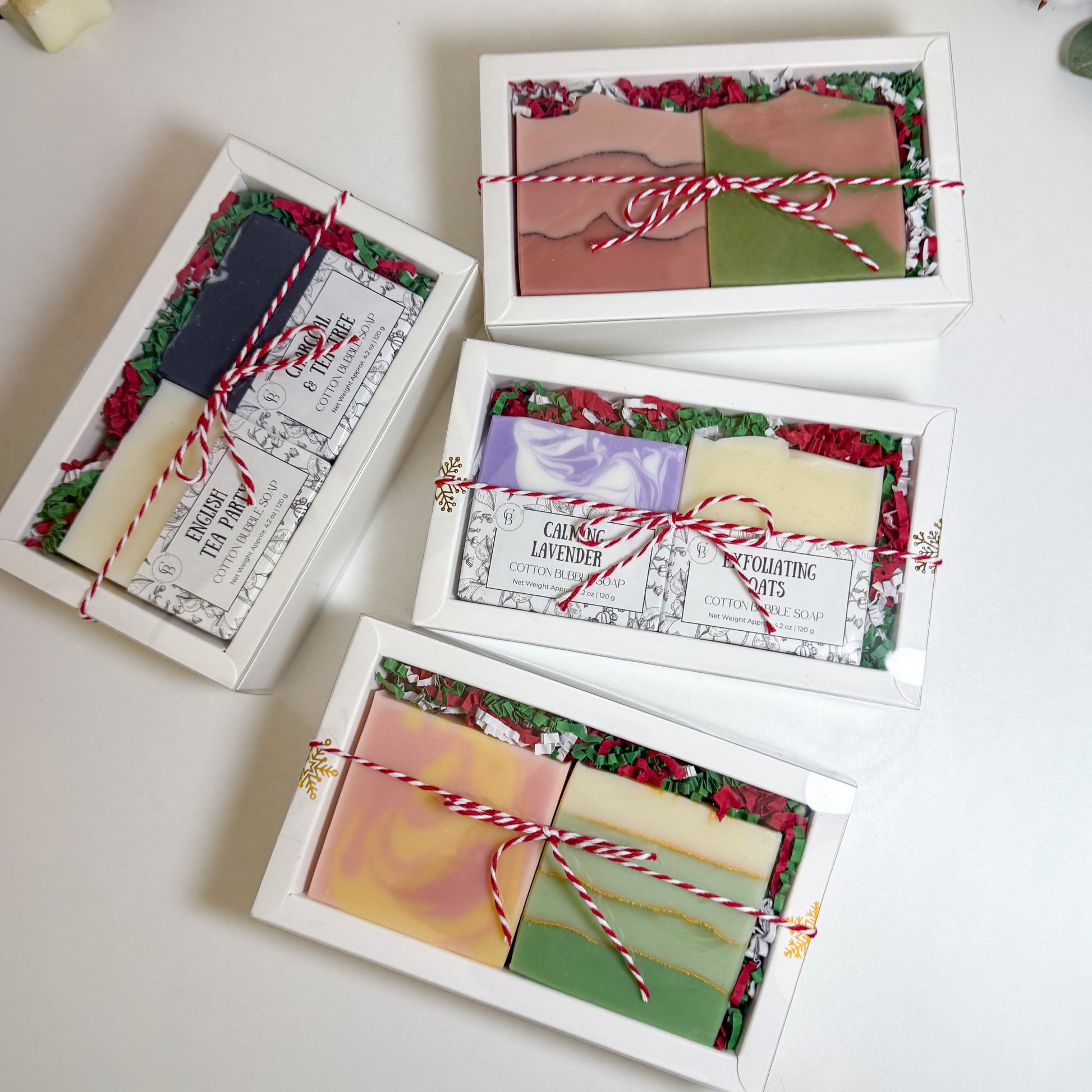 Set of soap bars in decorative boxes with colorful labels on a white surface