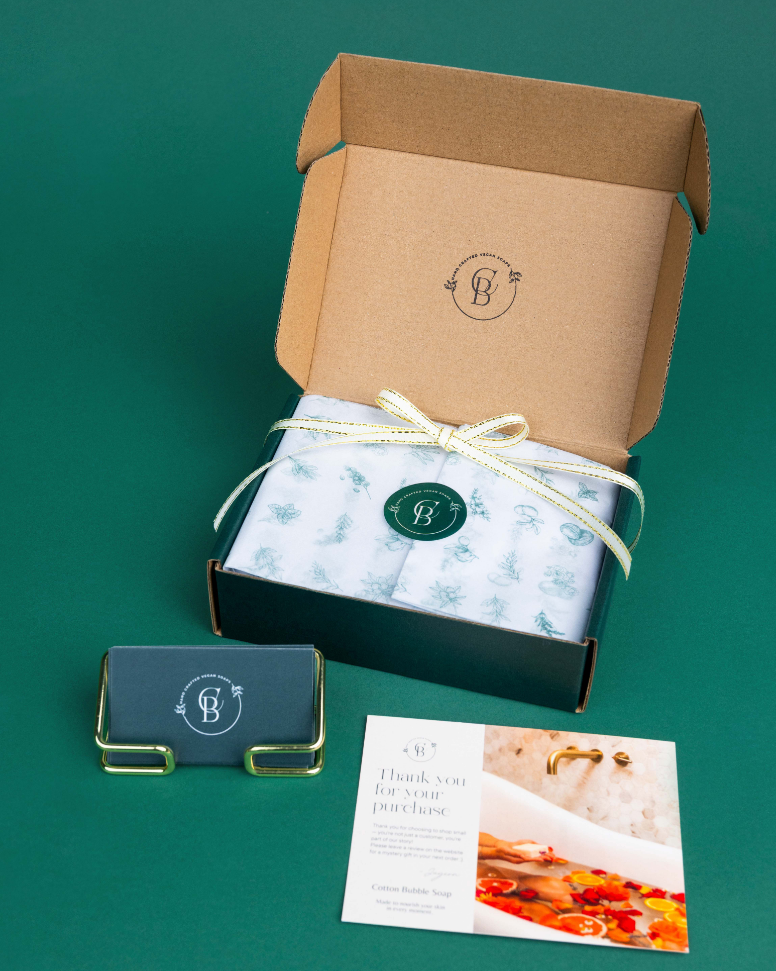Gift box with a bow, card, and product image on a green background