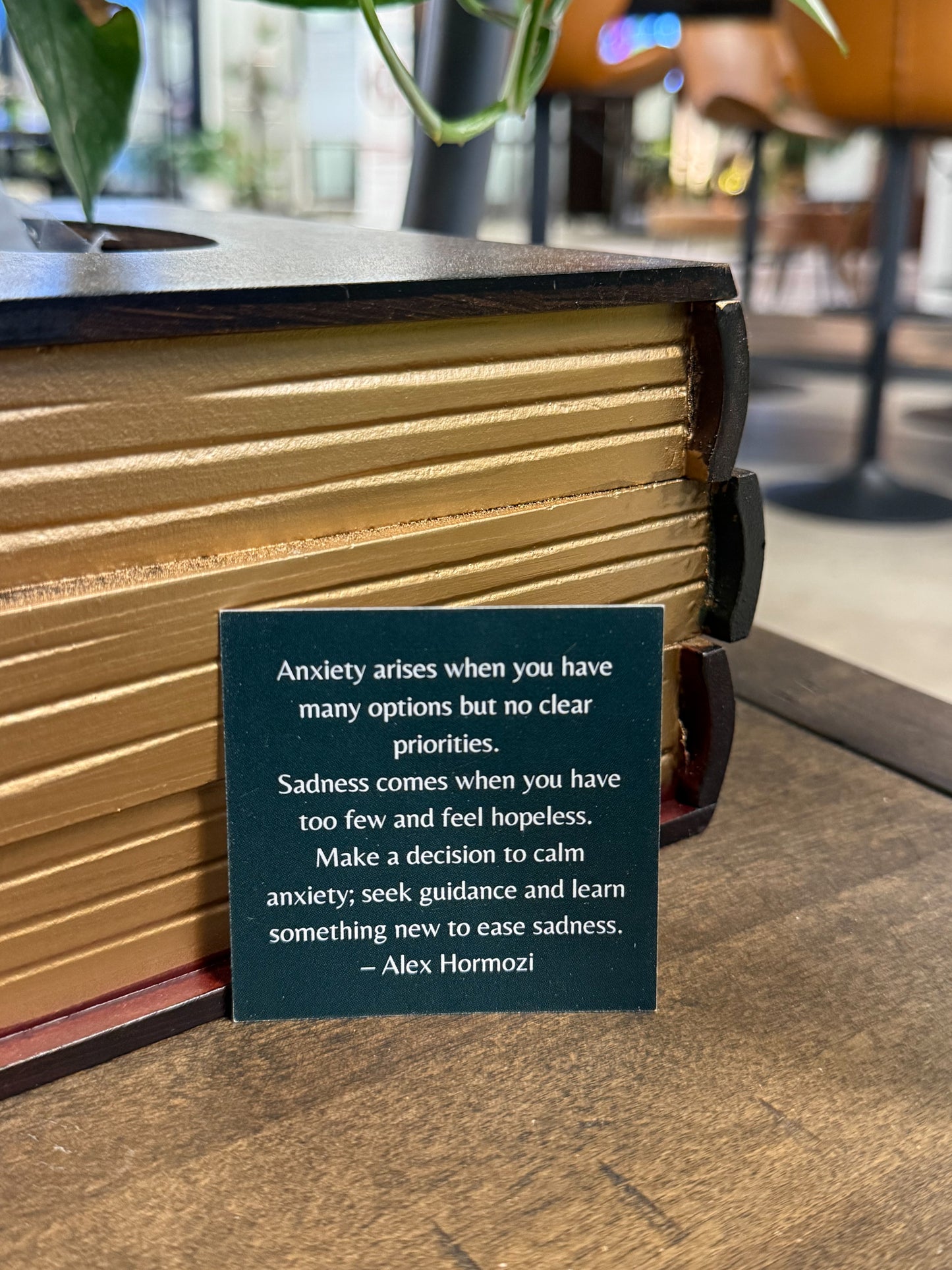 Book with a quote card on a wooden surface, blurred background