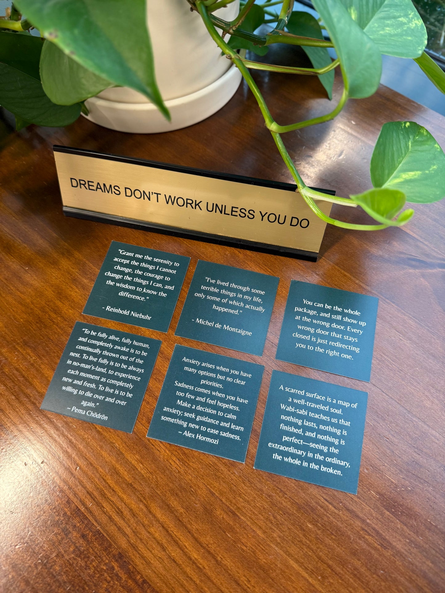 Motivational sign on a wooden surface with inspirational cards below