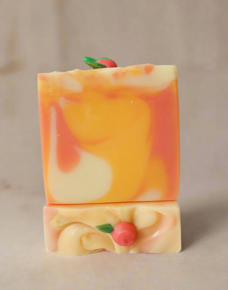 Two colorful soap bars with apple designs on a white background