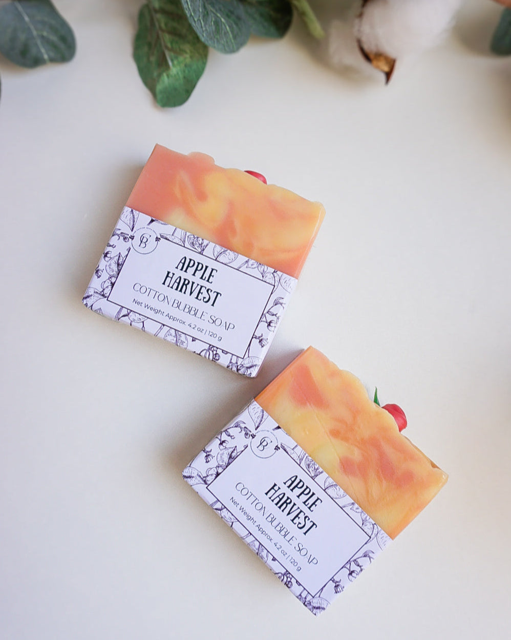 Two apple harvest soaps on a white background with a green leaf branch