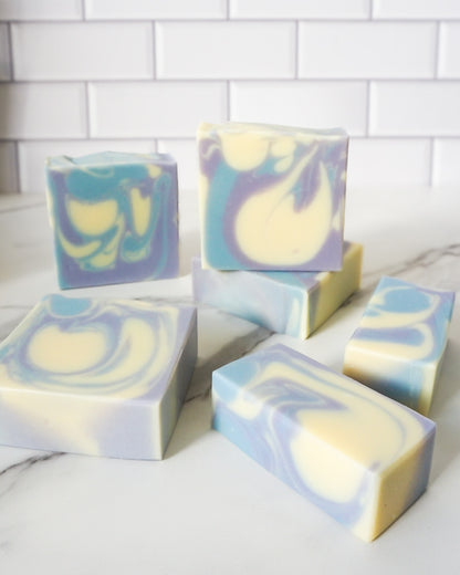 Colorful soap bars with a marble pattern on a white surface.