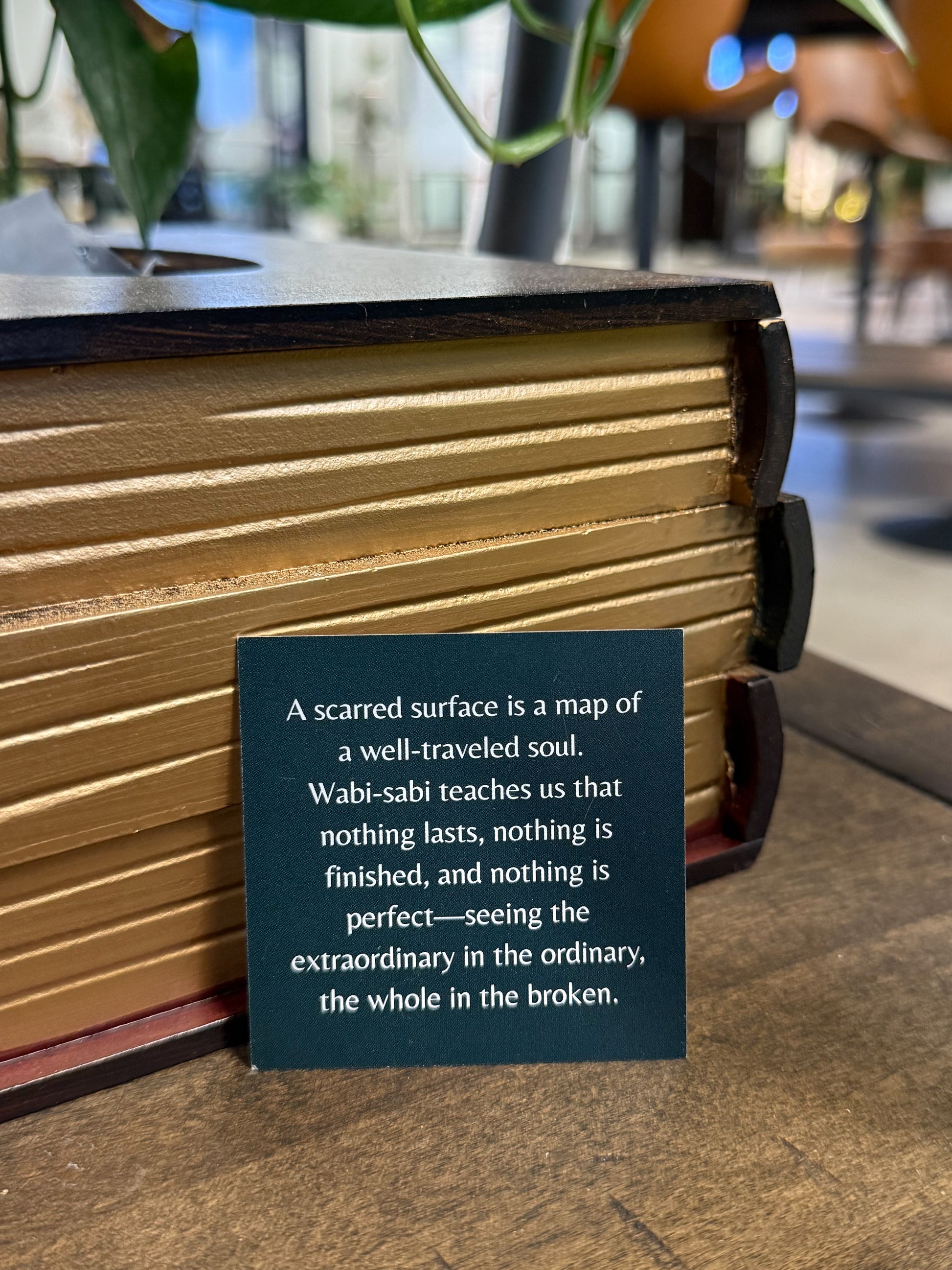 Book with a Wabi-sabi quote card on a wooden surface