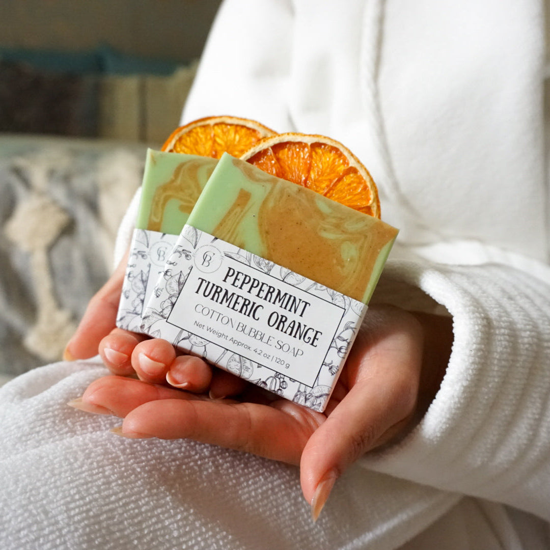 Person holding two soap bars with visible branding and text