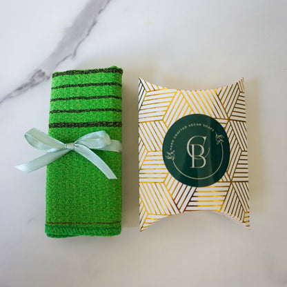Green bath towel with a decorative box on a marble surface