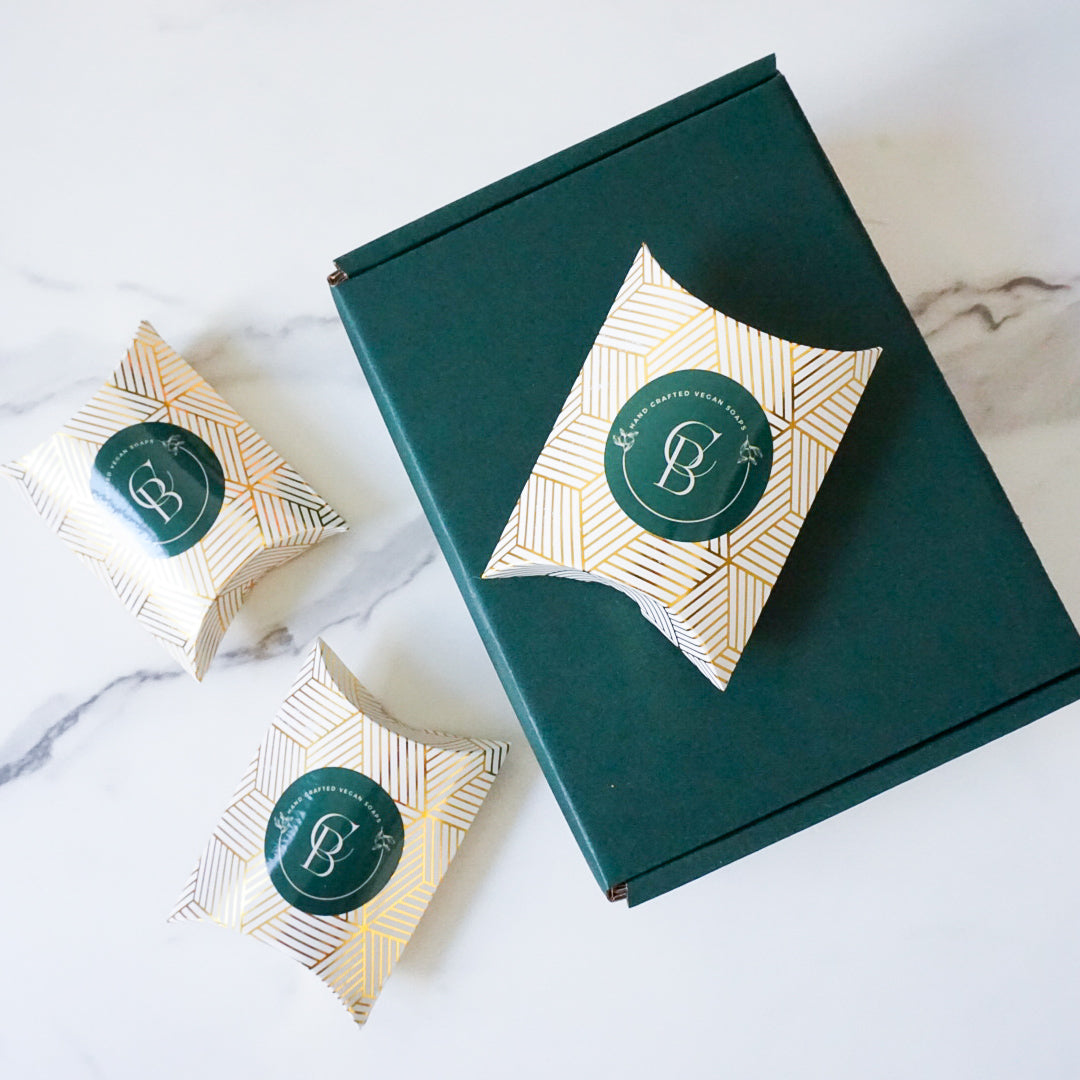 Green gift box with decorative packaging on a marble surface to showcase the packaging for the bath towel