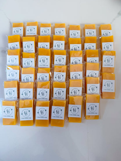 Multiple packs of yellow soap with white labels on a white background