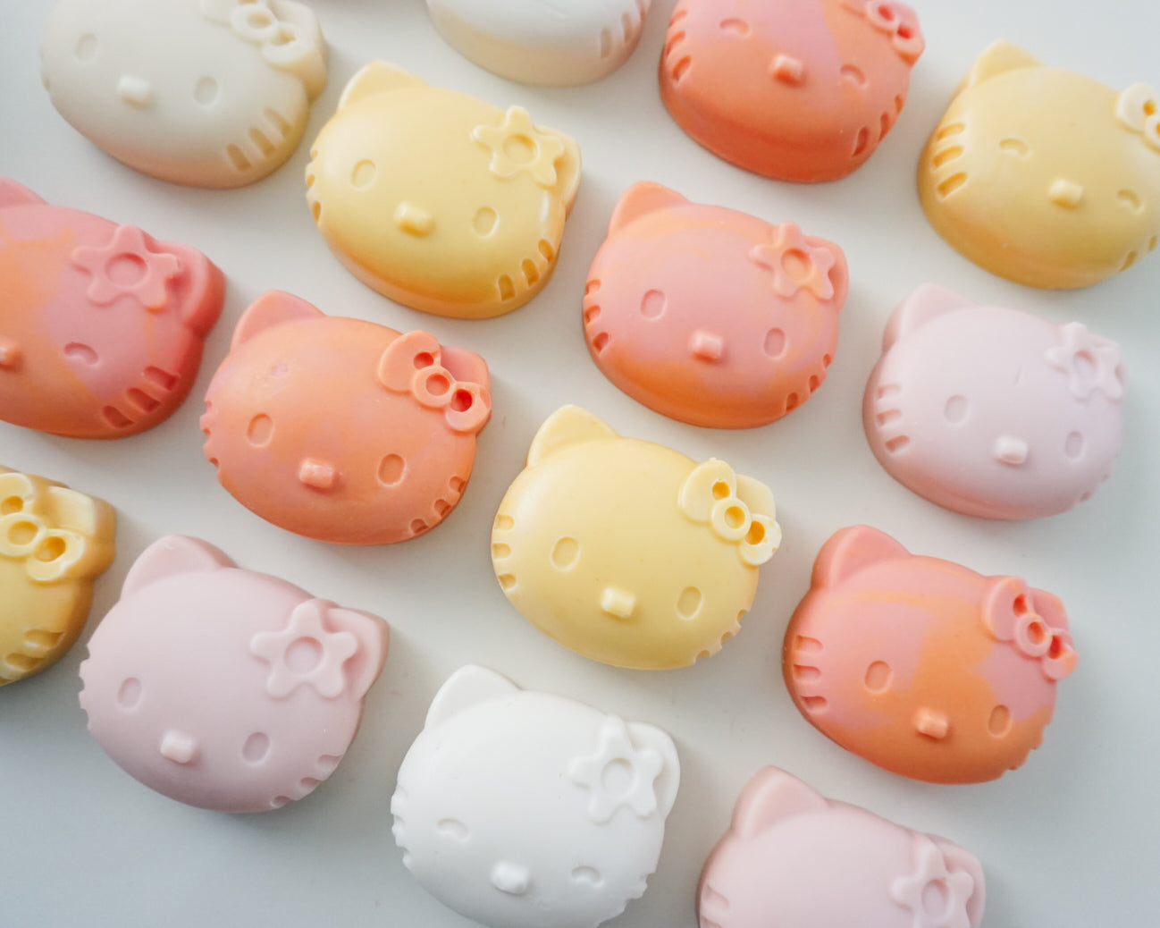 Hello Kitty-shaped soaps in various colors on a white background