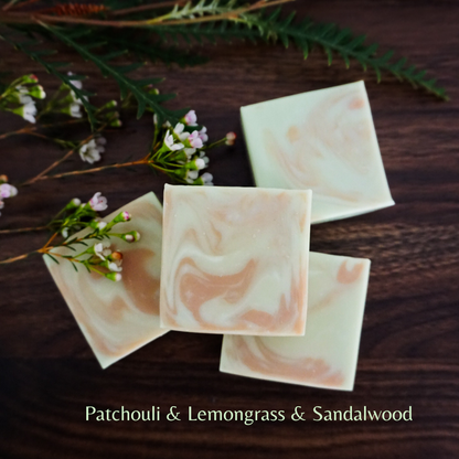 Marbled soap bars on a wooden surface with greenery