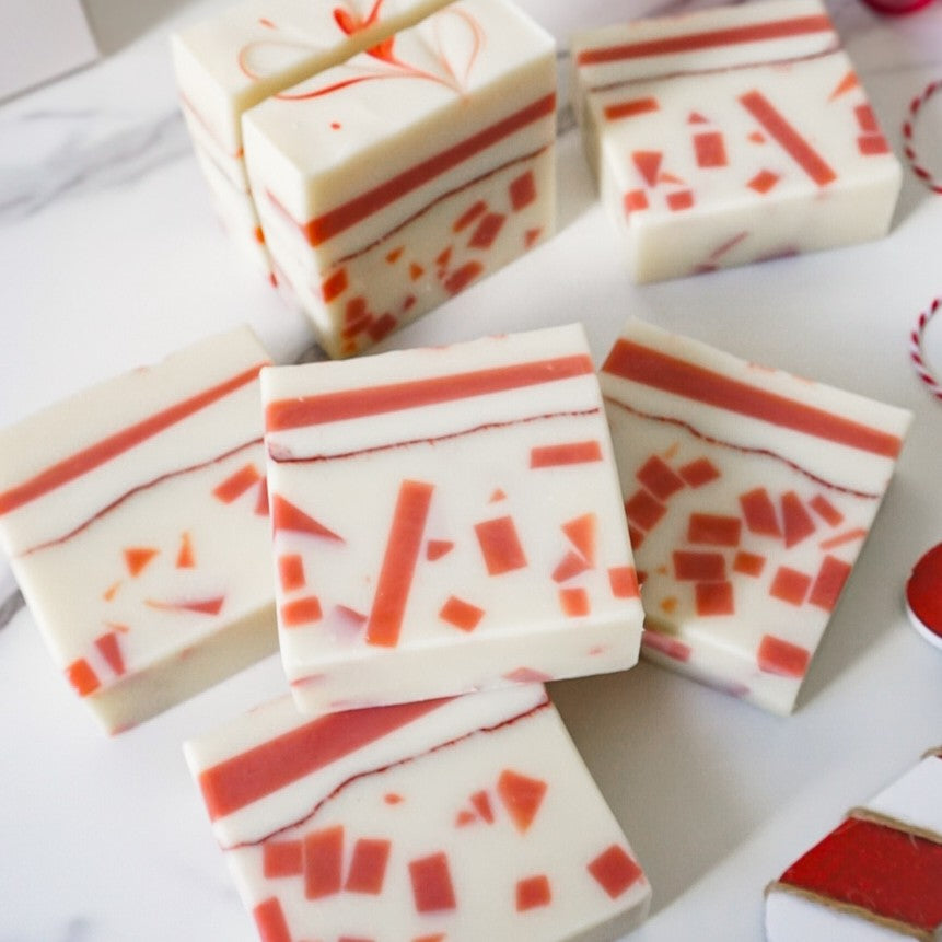 Marbled red and white soap bars on a white surface