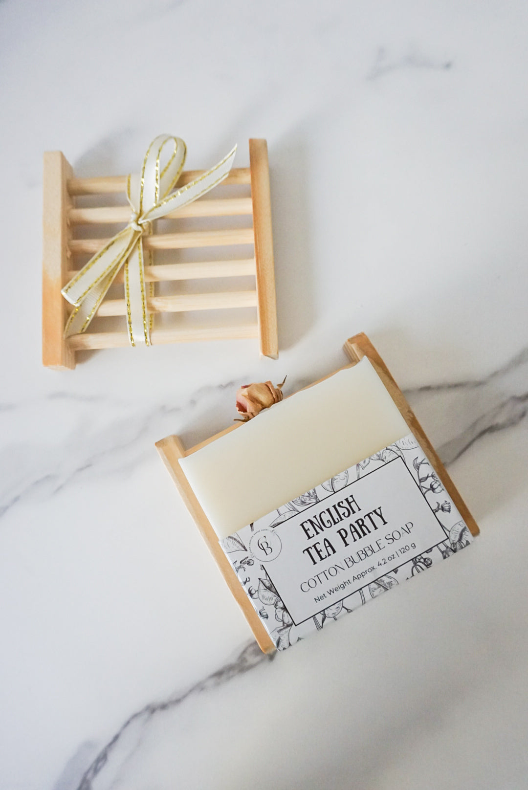Bar of soap in a decorative box with a bow on a marble surface