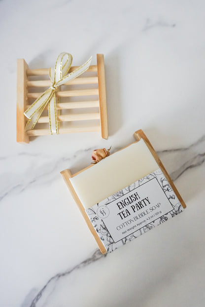 Bar of soap in a decorative box with a bow on a marble surface