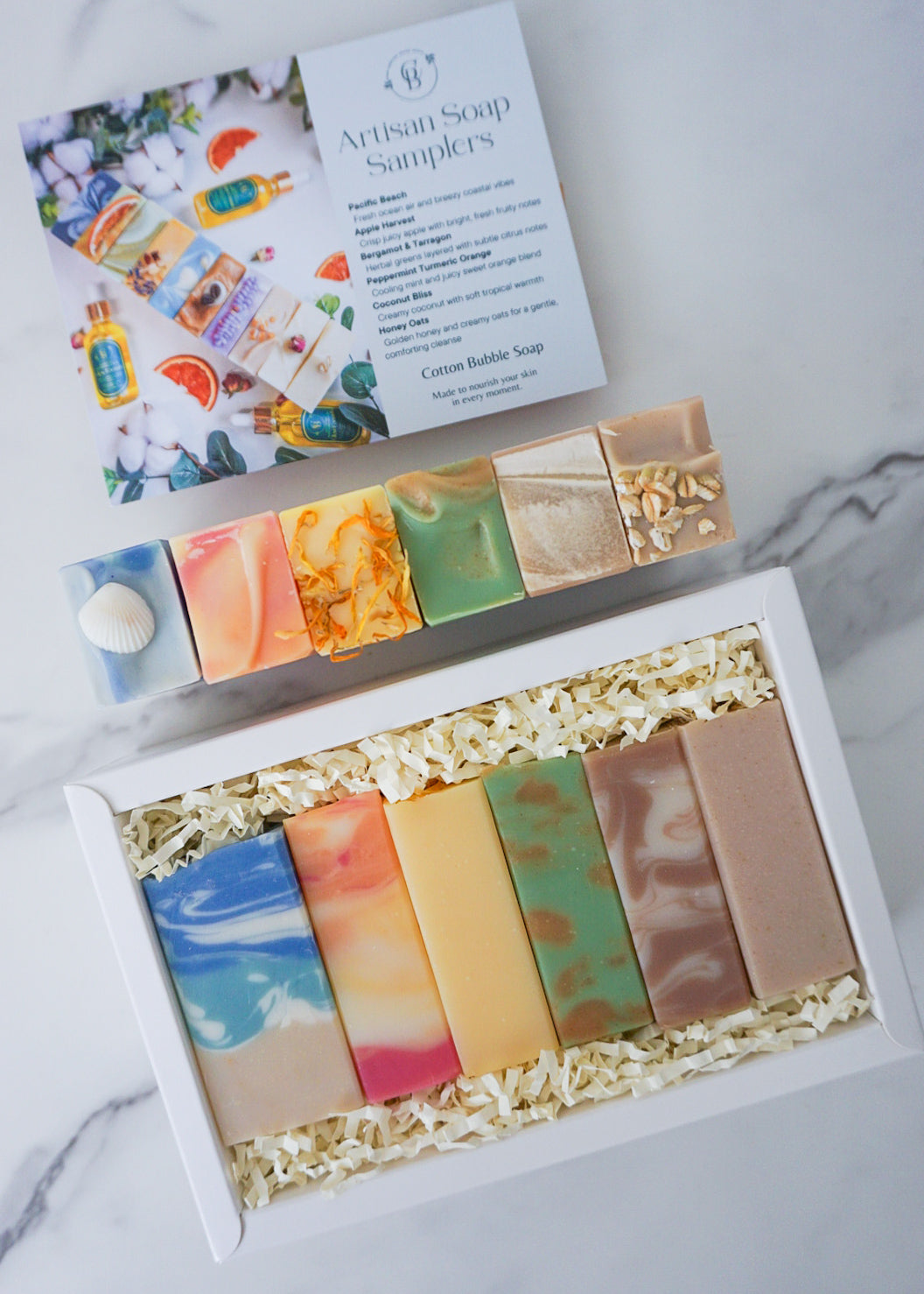 Artisan soap samplers in a box with a colorful label on a marble surface