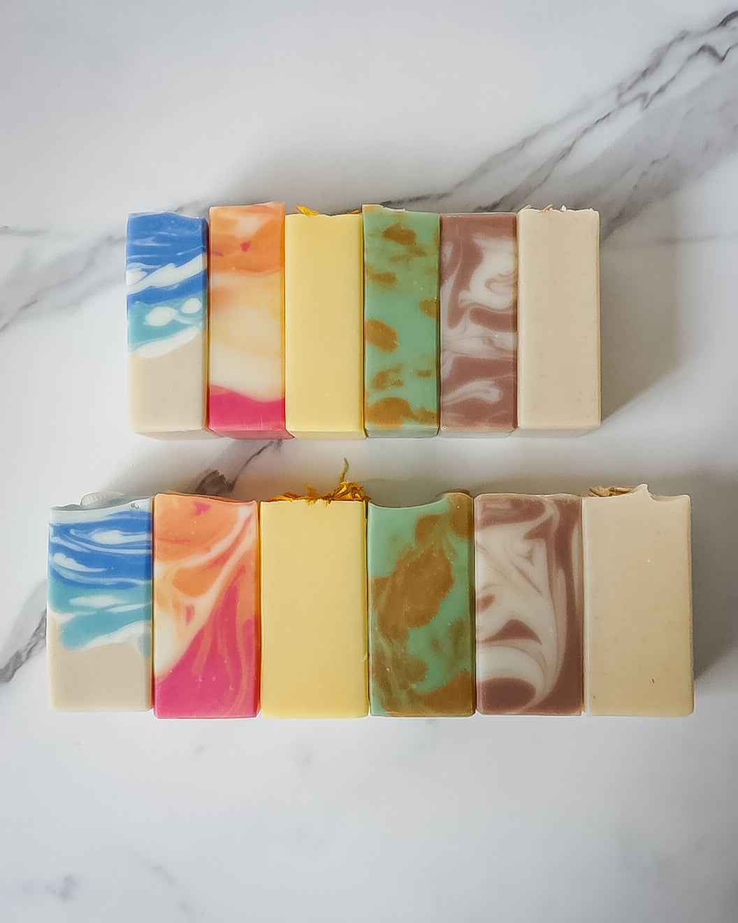 Assorted colorful soap bars on a marble surface