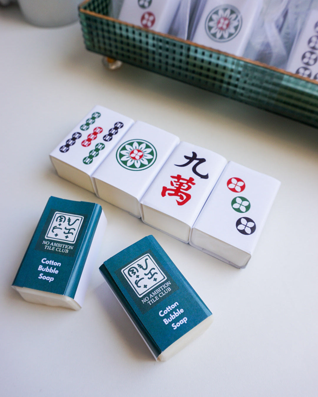 Mackie bubble soap bars with a set of Mahjong tiles on a white surface.